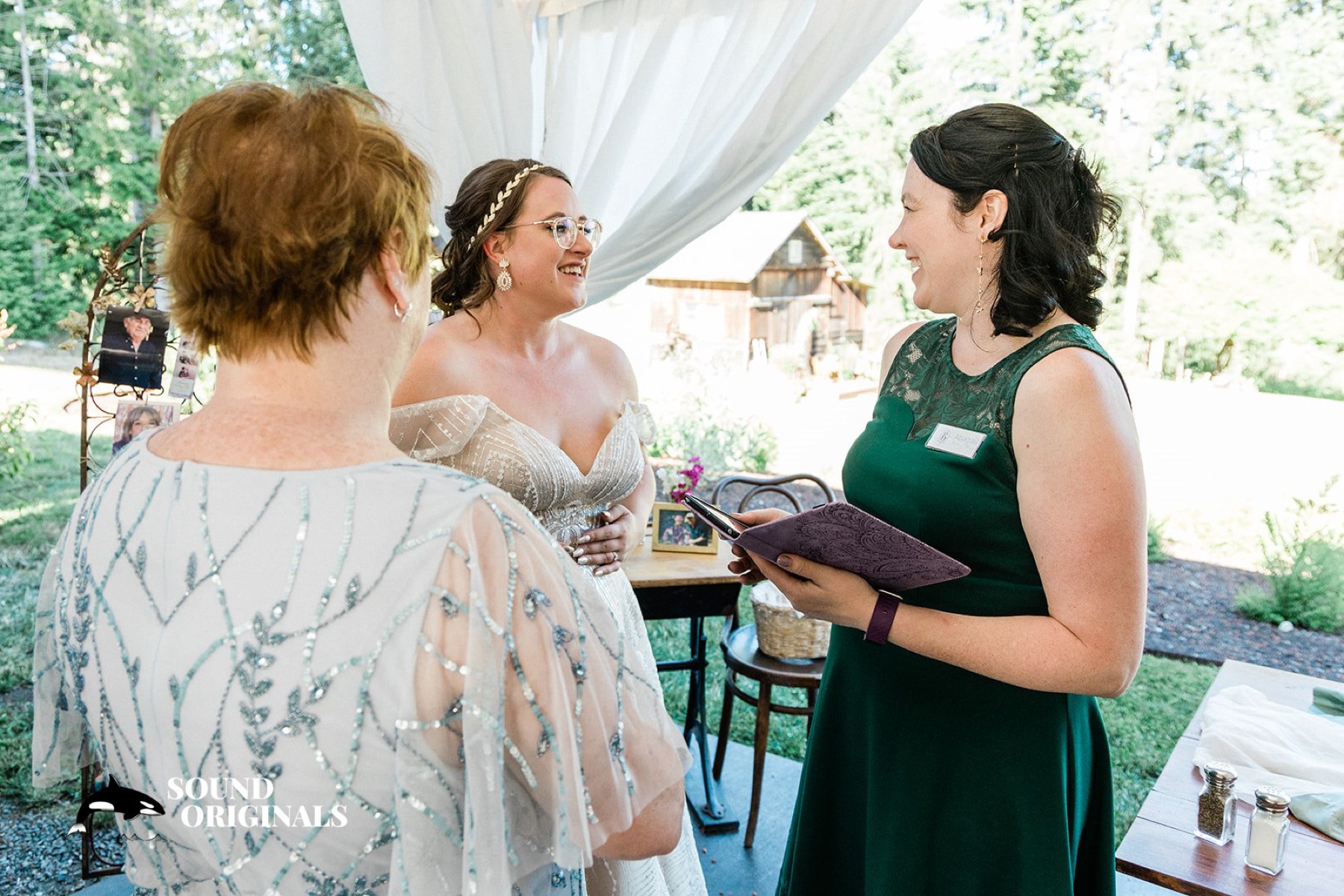 A planner reviewing a timeline with a couple at a sunlit table